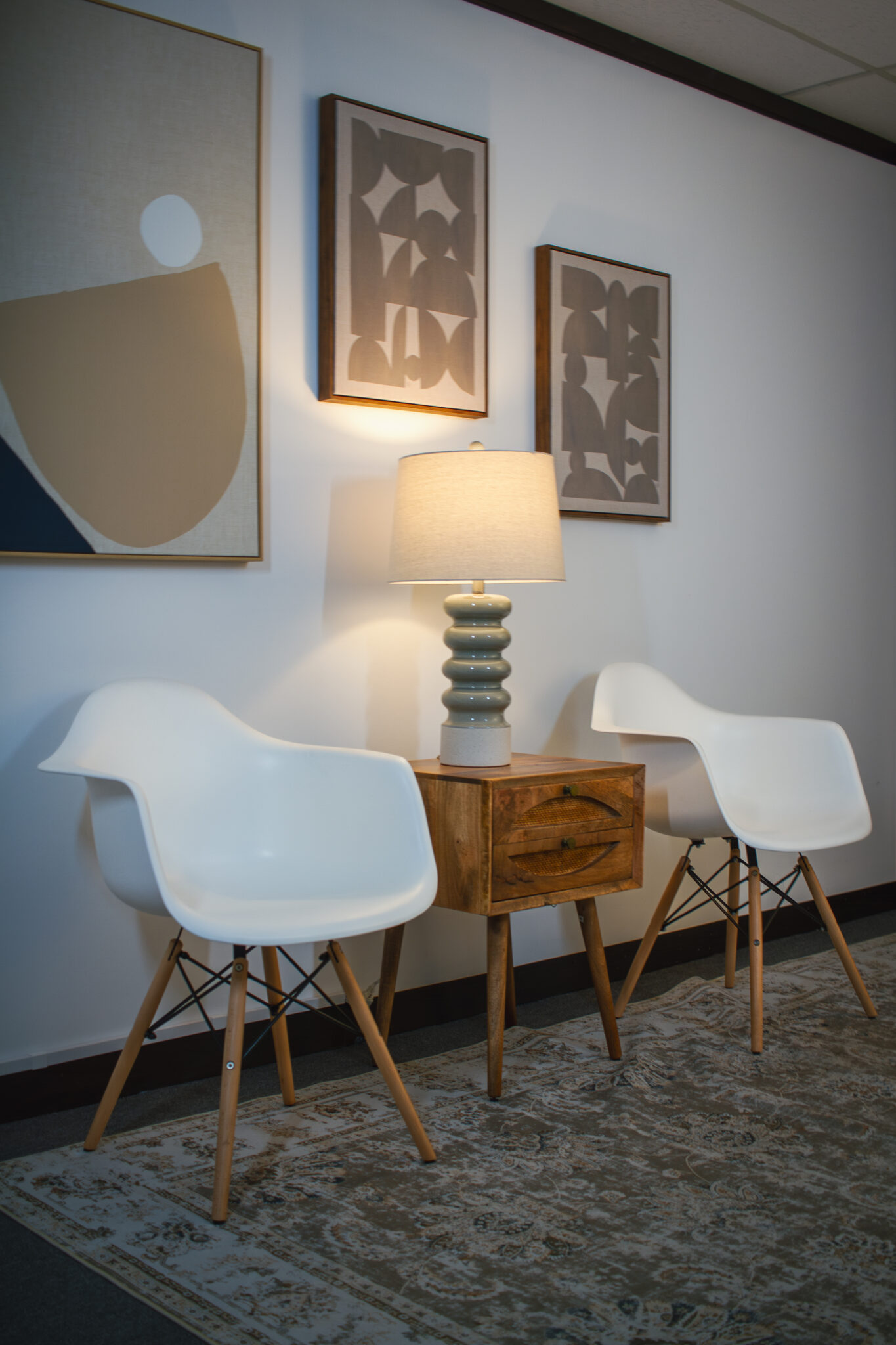 A waiting room in a therapist's office. Two white chairs, side by side, with a lamp in between.